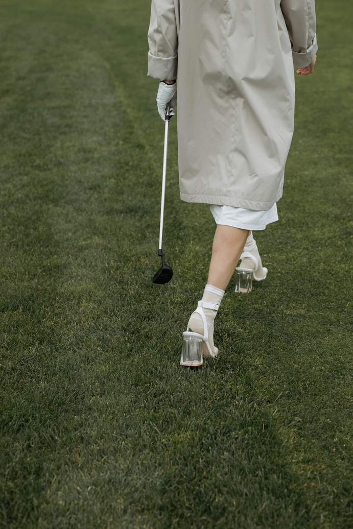 Person in High Heels Walking on Golf Field